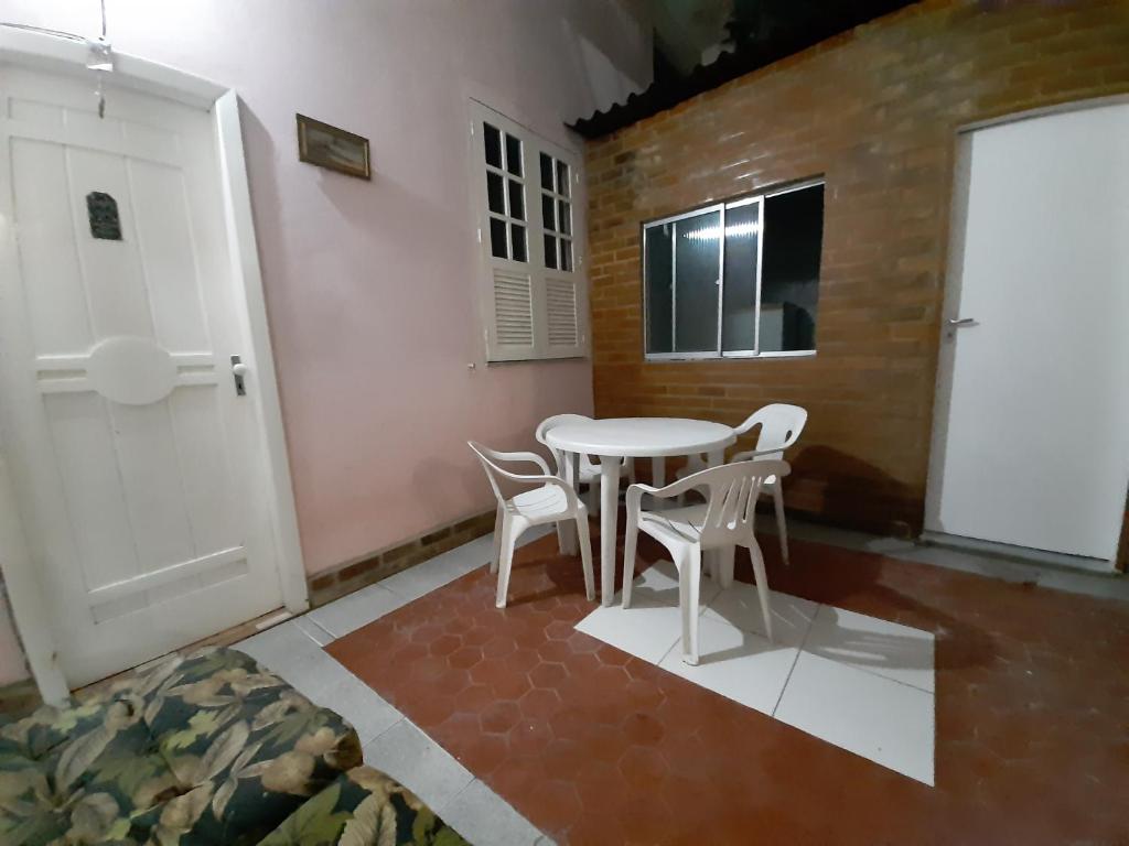 a room with a table and chairs and a door at Quarto Suite na Gavea in Rio de Janeiro