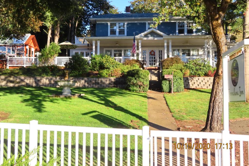 a white picket fence in front of a house at Terraluna Inn in Roseburg