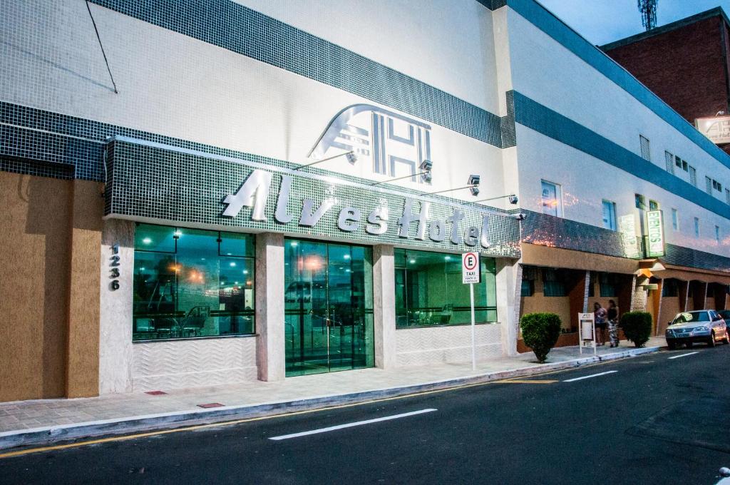 a building with a sign on the side of a street at Alves Hotel in Marília