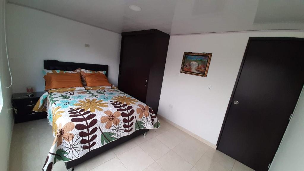 1 Schlafzimmer mit einem Bett mit Blumendecke in der Unterkunft Apartamento Ynj Bogot in Bogotá