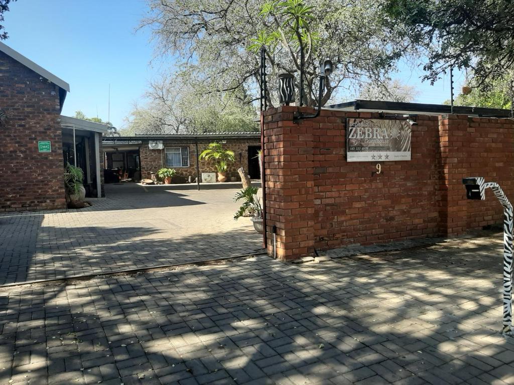 a brick building with a sign on the side of it at Zebra Guesthouse in Lephalale