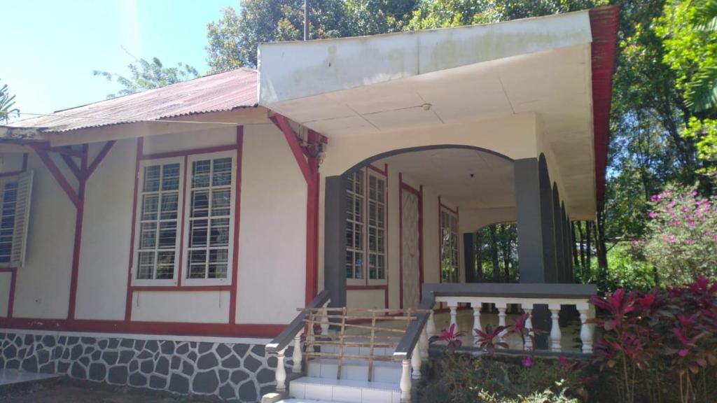 a small pink house with a porch and stairs at Villa Yasmin Malino in Malino