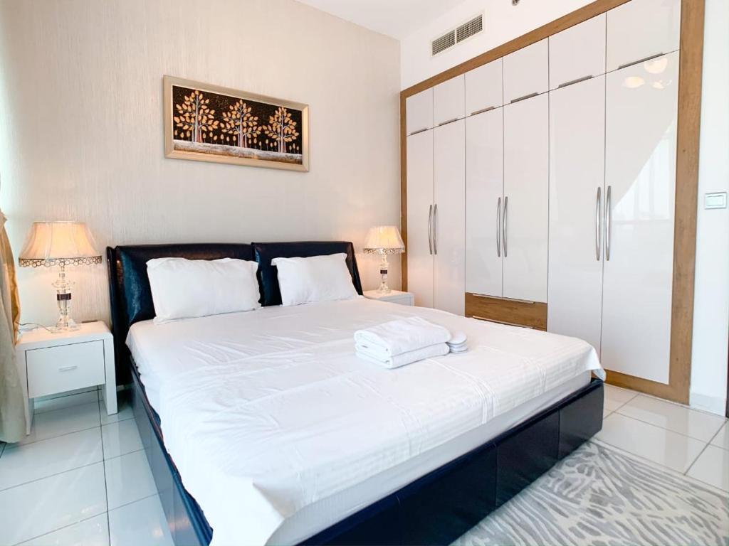 a bedroom with a large bed with white sheets at OYO 557 Home Starz Danube T2 -105 in Dubai