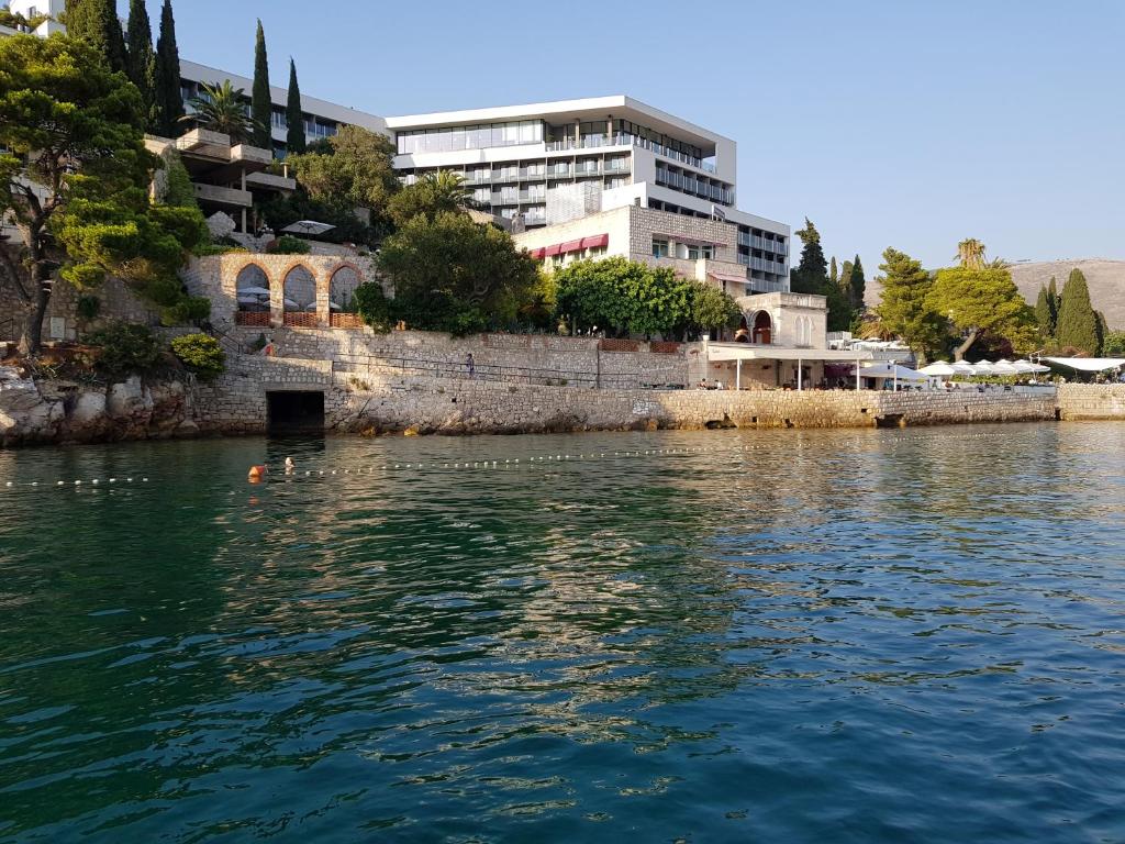 una gran masa de agua con un edificio en el fondo en Boutique & Beach Hotel Villa Wolff, en Dubrovnik