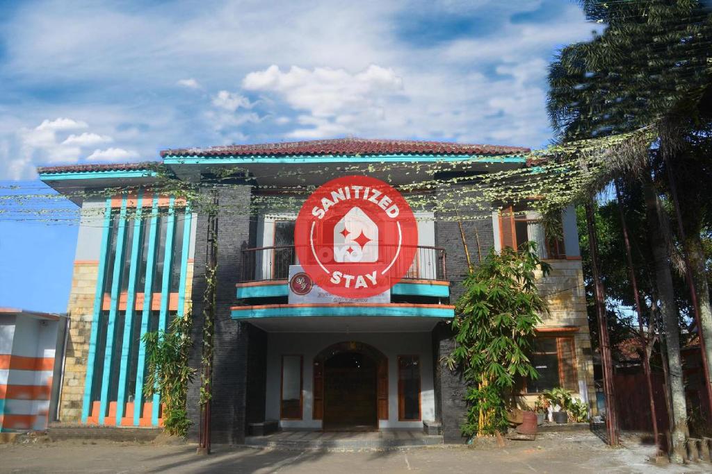 un bâtiment avec un panneau rouge à l'avant dans l'établissement Super OYO 1240 Hotel Pantai Jaya, à Pangandaran