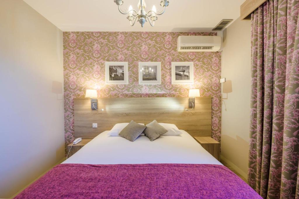 Postel nebo postele na pokoji v ubytování Hôtel l'Aragon