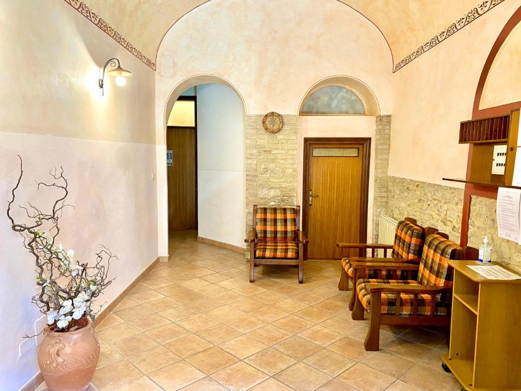 un vestíbulo con sillas y un jarrón de flores en Residence Signa, en Perugia