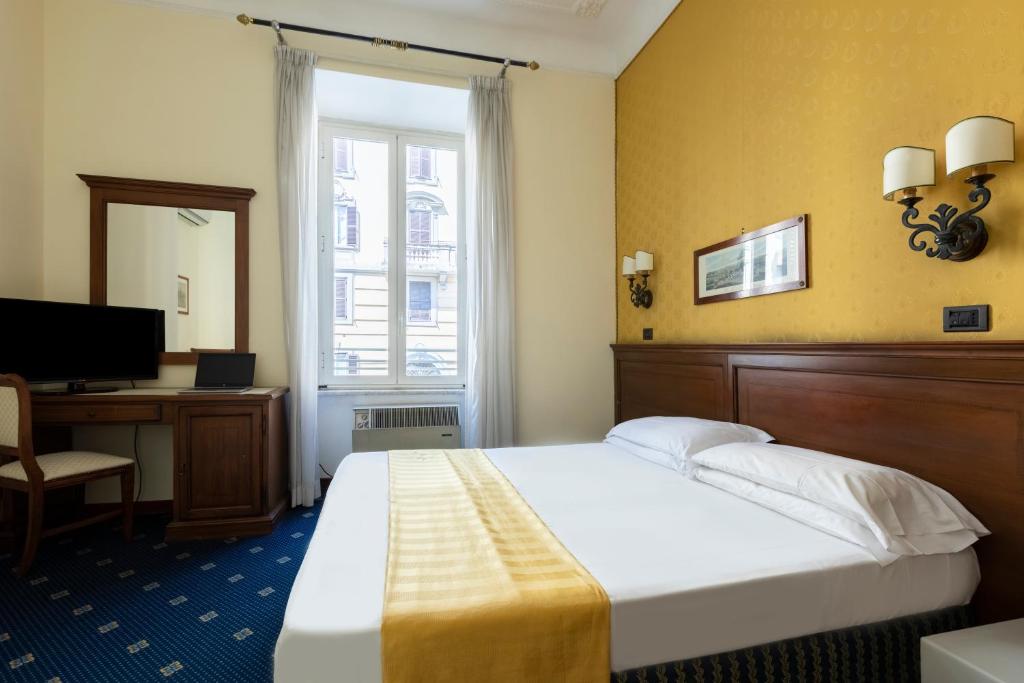 a hotel room with a bed and a desk and a window at Hotel Coppede' in Rome