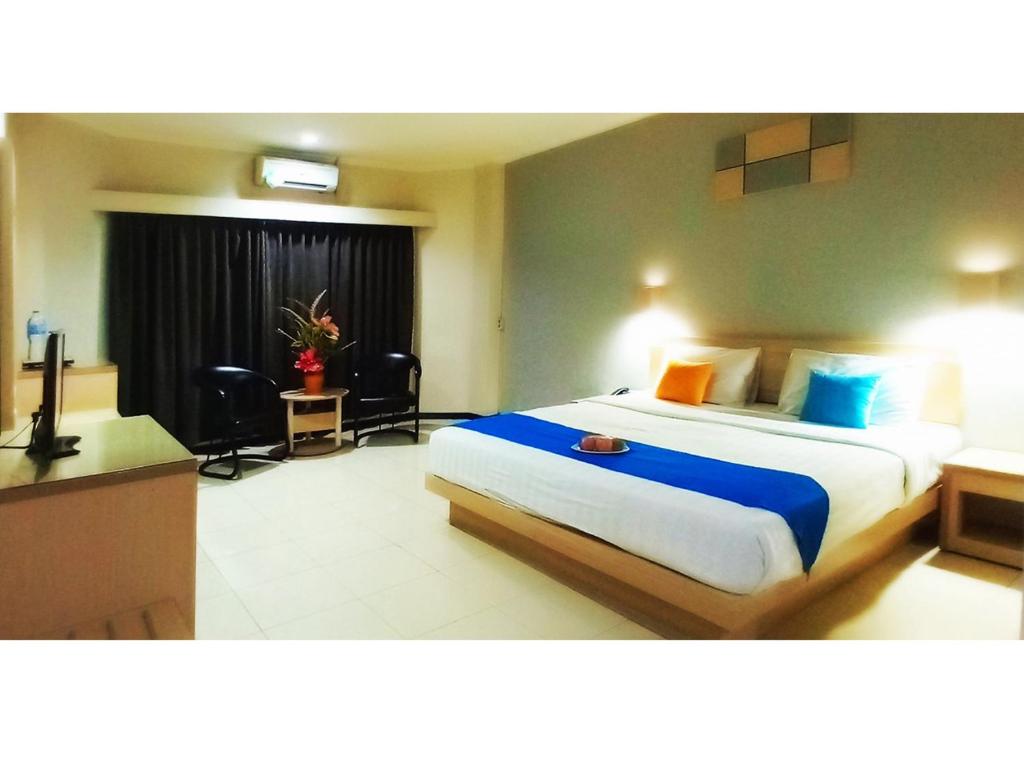 a hotel room with a large bed and a desk at Merpati Hotel in Pontianak