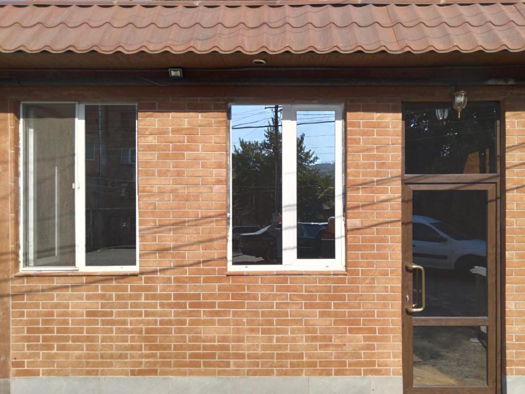 a brick building with three windows and a door at Arm Hotel in Yerevan