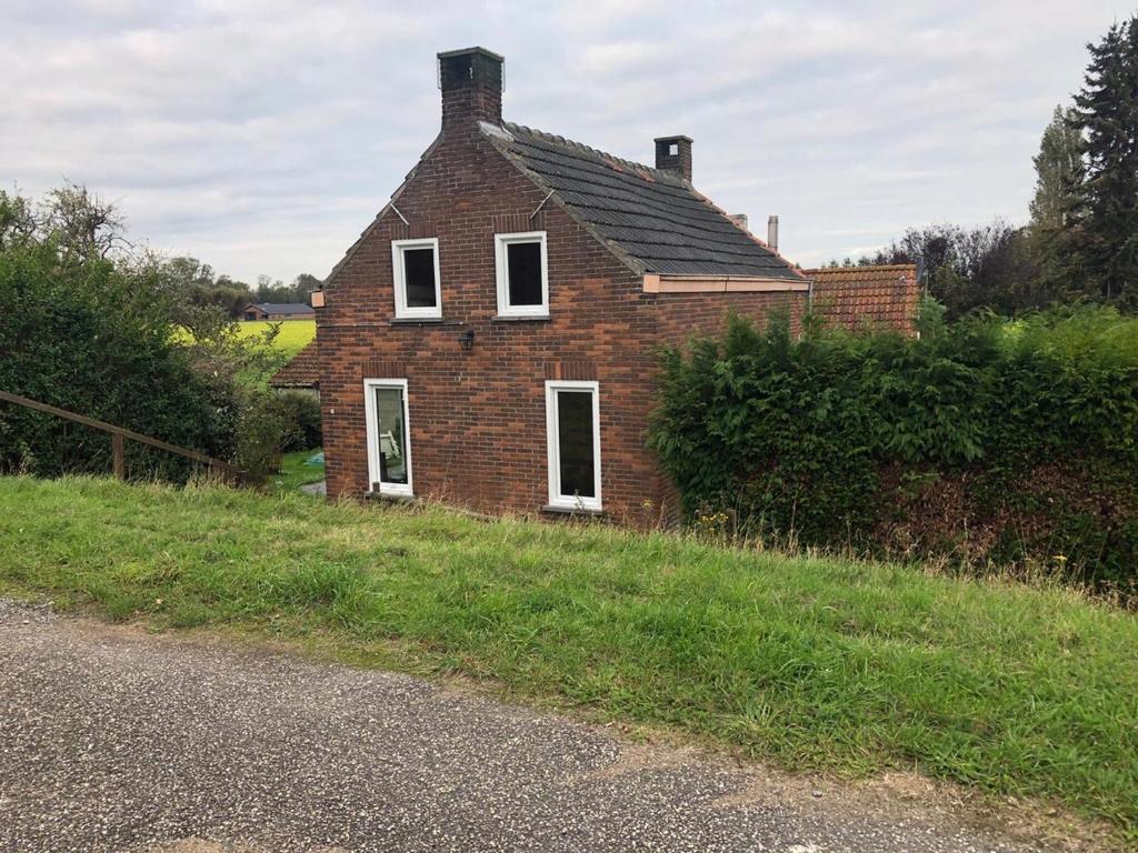 an old brick house on the side of a road at Dikehouse at sea in Walsoorden