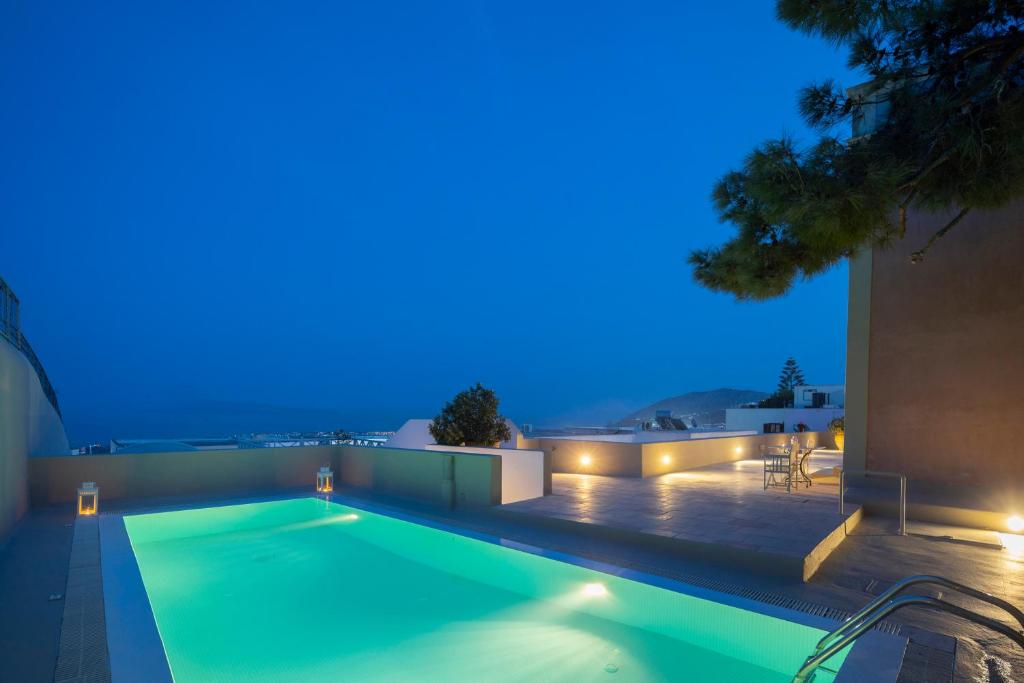 a swimming pool in the middle of a house at night at Aria Lito Mansion in Fira