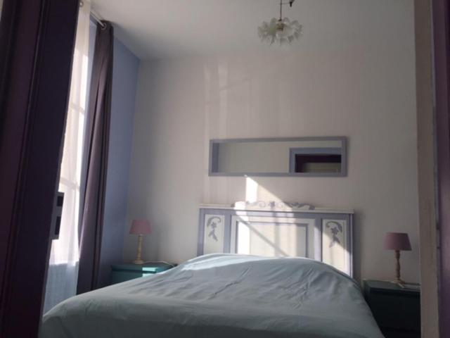 um quarto com uma cama branca e uma janela em Chambre Saint-Sauveur em Les Andelys