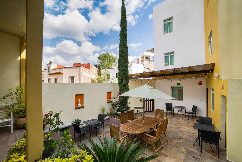 a patio with a table and chairs and an umbrella at Casa Santa Fe, Guanajuato in Guanajuato