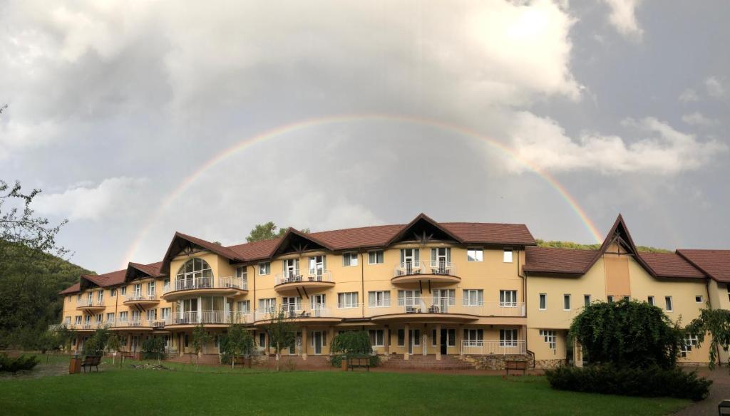 un arco iris en el cielo sobre un gran edificio en Belle Royalle, en Lisarnya