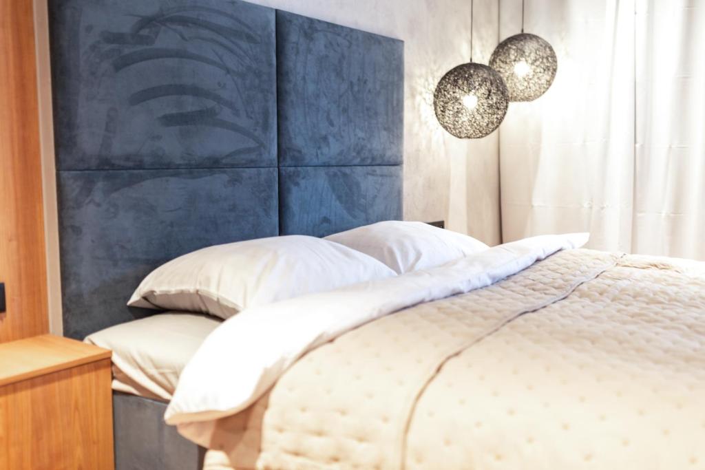 a bedroom with a bed with a blue headboard at Baltic Apartments Main Town Towers in Gdańsk