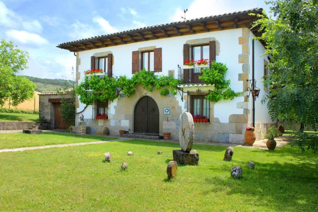 een huis met een stel vogels ervoor bij Casa rural Mertxenea Landetxea in Elcano
