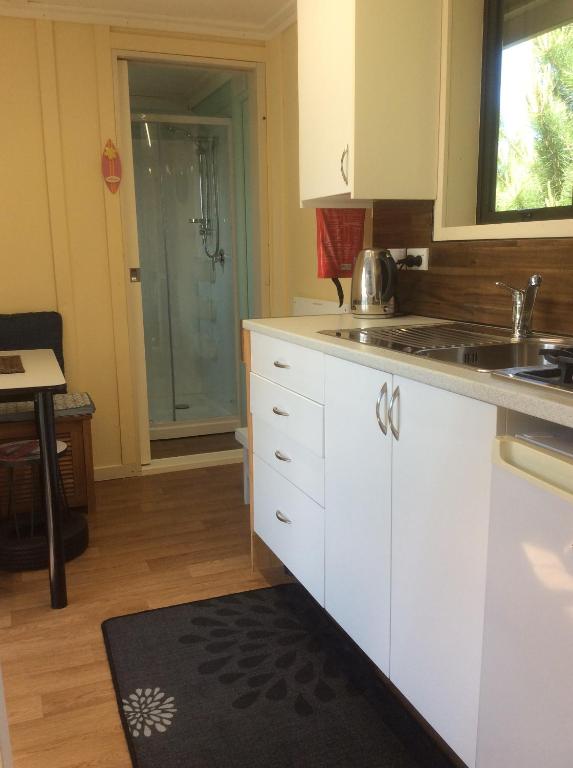 a kitchen with white cabinets and a sink and a shower at Oxford Tiny House in Oxford