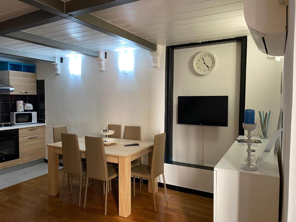 una sala da pranzo con tavolo e orologio a parete di Vacanza al Ponte Reale a Genova