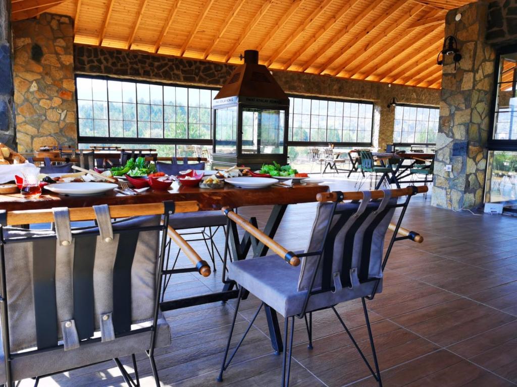 a dining room with a large wooden table and chairs at Fikri Atalay Konağı Bungalov Evleri in Mengen