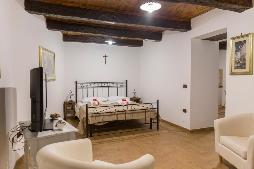 - une chambre avec un lit et une télévision dans l'établissement Casa Vacanze Porta Manfredi, à Arce