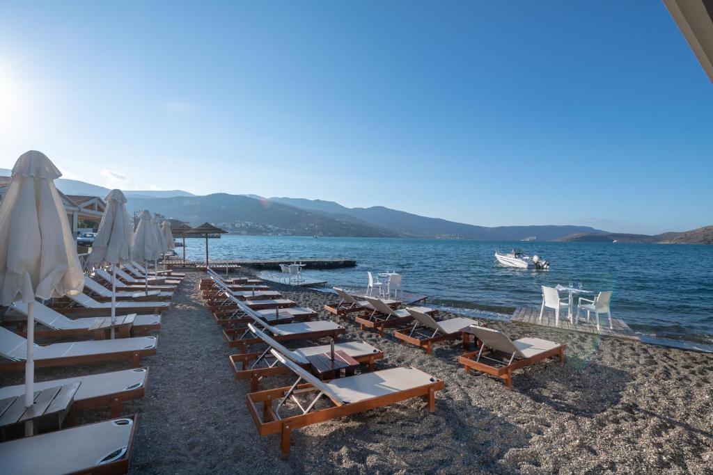 a row of chairs and umbrellas on a beach at Elounda Akti Olous (Adults Only) in Elounda