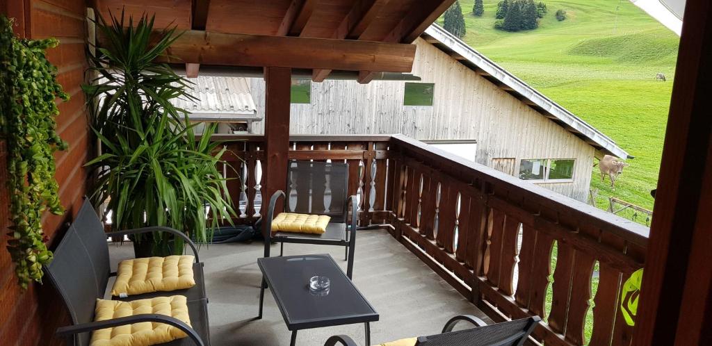 un balcón con mesa y sillas y un granero en Bauernhof Sot Curtegns en Savognin