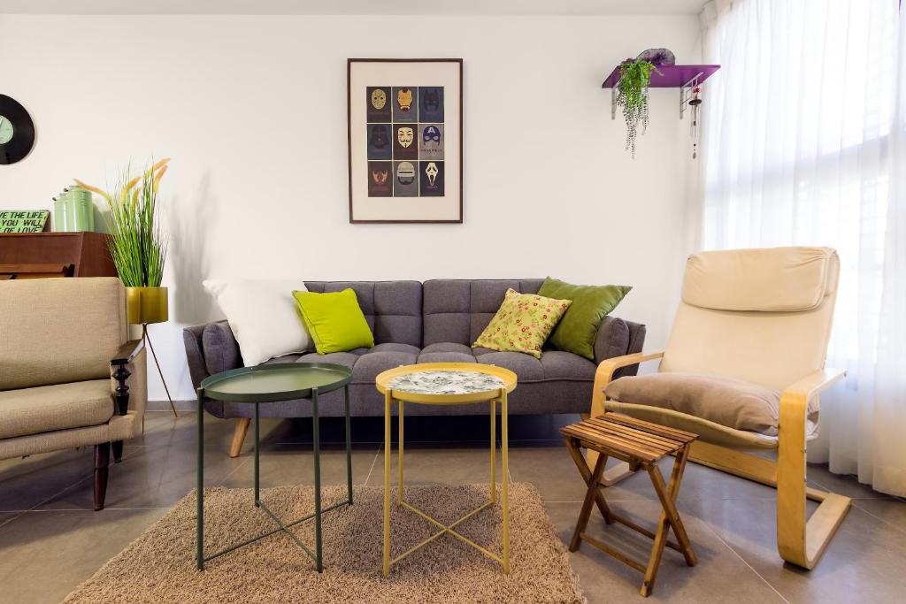 sala de estar con sofá y sillas en La Maison de Raphael, en Netanya