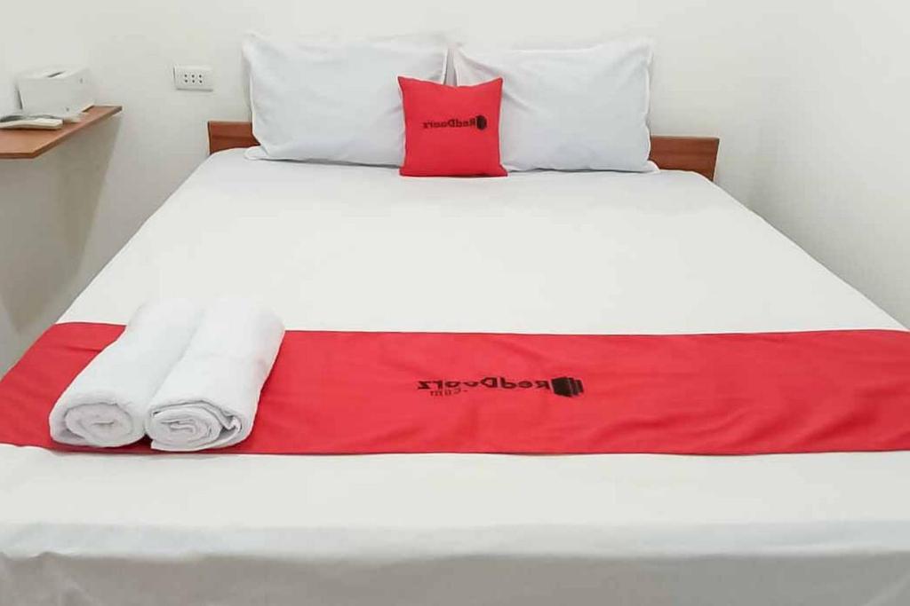 uma cama com duas toalhas e duas almofadas em RedDoorz Plus near Universitas Saburai Lampung em Lampung