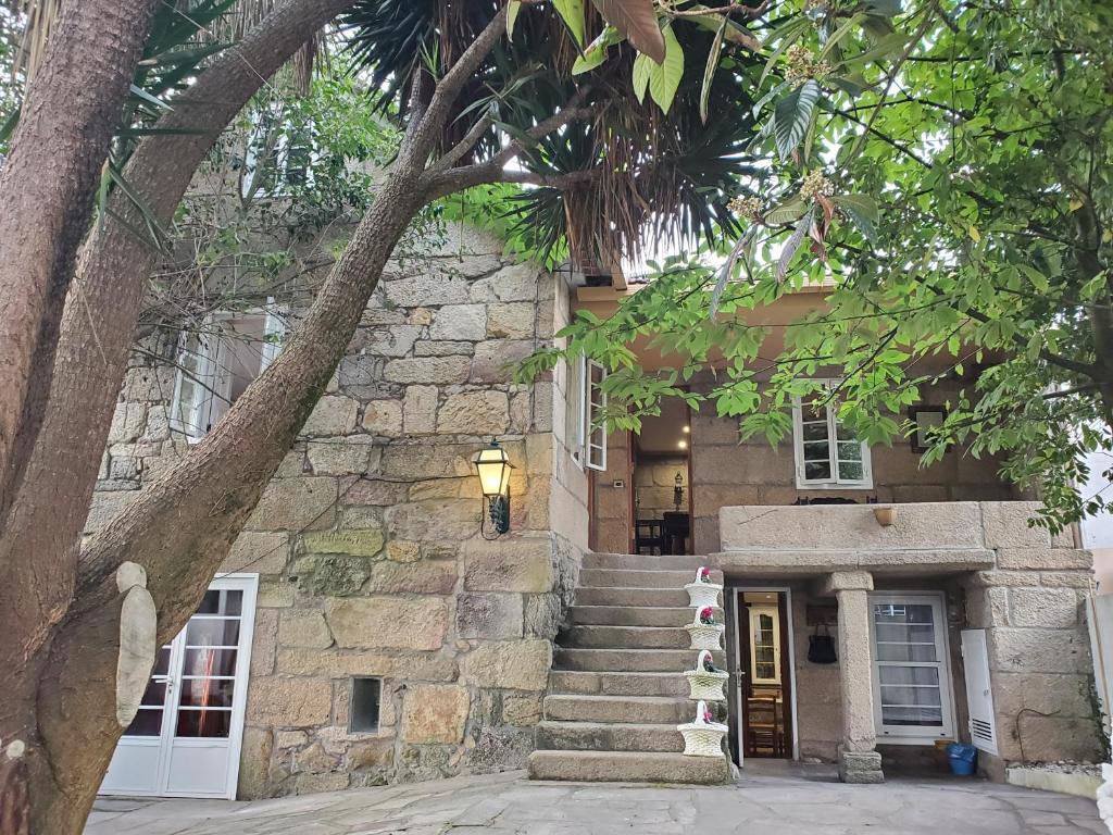 a stone building with stairs leading to a door at CASA O´PACIÑO in Vigo