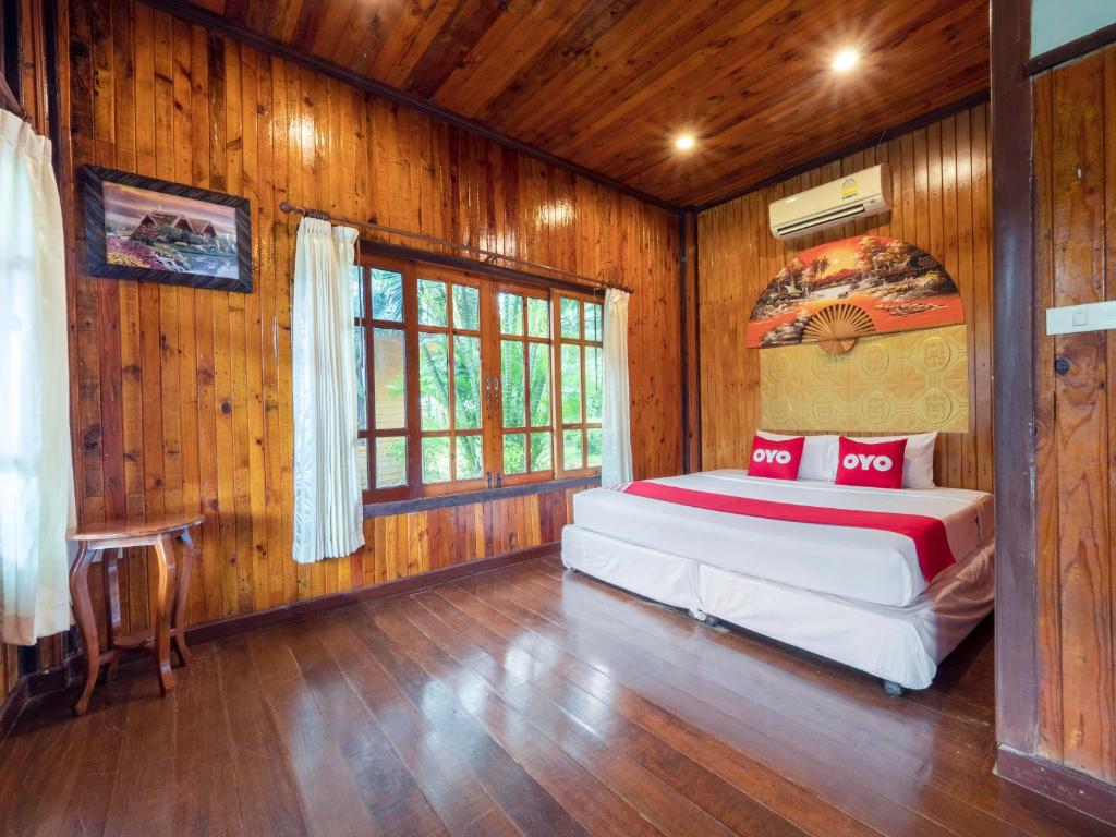 a bedroom with a bed in a room with wooden walls at OYO 75336 Blue resort & spa in Ko Chang
