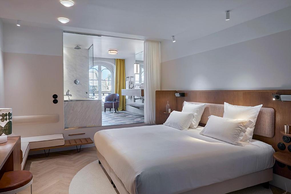 um quarto com uma cama grande e uma casa de banho em Hôtel du Sentier em Paris