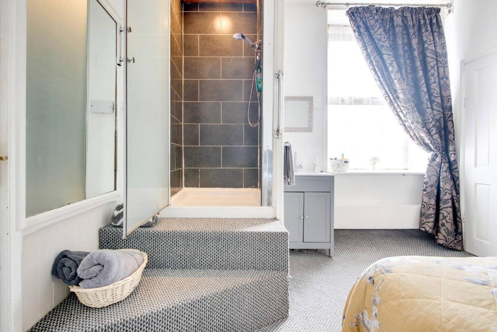 a bathroom with a walk in shower next to a bed at Hooton Apartment 1 bed in Kilnhurst