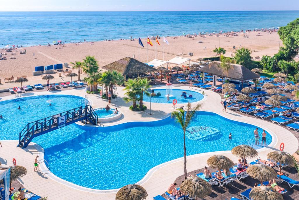 einen Luftblick auf einen Resortpool und den Strand in der Unterkunft Hotel Tahití Playa in Santa Susanna