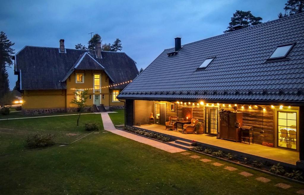 een huis met een patio in de tuin 's nachts bij Bergervilla Boutique Guest House & SPA in Mežmuiža