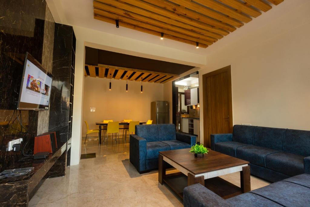 una sala de estar con sofás azules y una mesa. en Back Stayz Hostel, en Rishīkesh