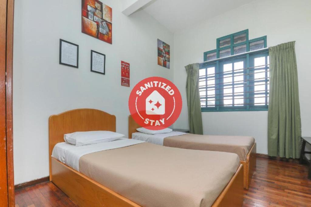 2 camas en una habitación con un cartel en la pared en SPOT ON 89789 Hotel Check In 2 en Brinchang