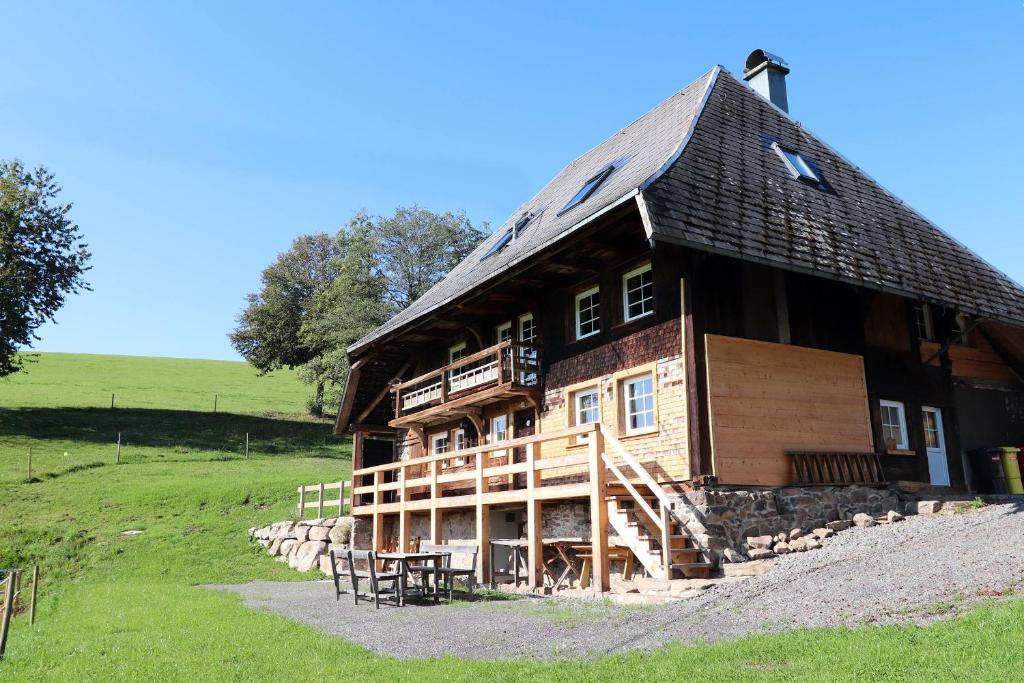 a large wooden house on a hill in a field at Ferienhütte Biobetrieb Lippenhof in Breitnau