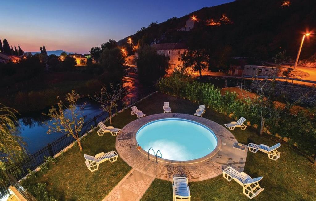 una vista aérea de una piscina con tumbonas y un río en Villa Cascata, en Trilj