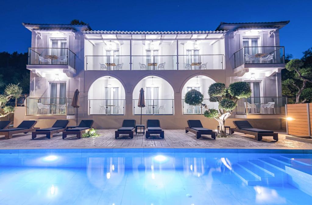 a hotel with a swimming pool in front of a building at Litore Luxury Living in Laganas