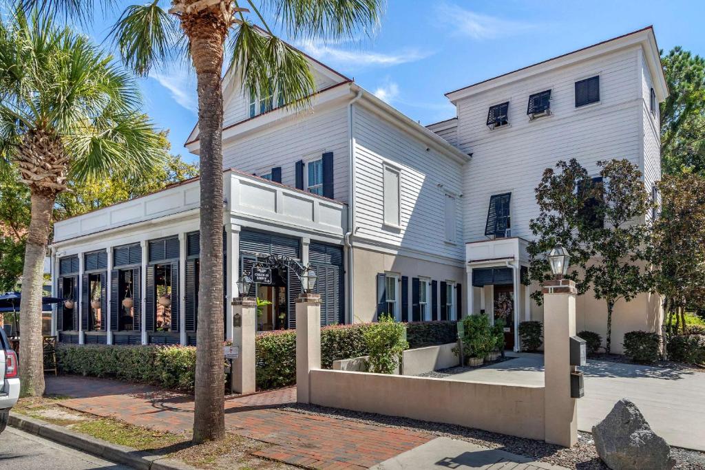 a white house with a palm tree in front of it at Inn at I'On, Ascend Hotel Collection in Charleston