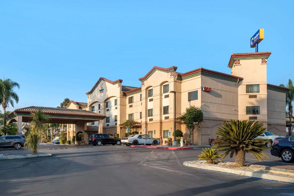 a hotel with cars parked in a parking lot at Comfort Suites in Redlands