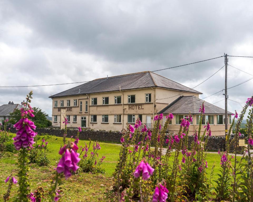 een groot gebouw met roze bloemen ervoor bij The Moorland Hotel in Wotter