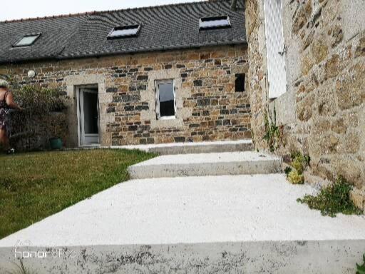 un bâtiment en briques avec deux marches devant lui dans l'établissement Le nid breton, à Lézardrieux