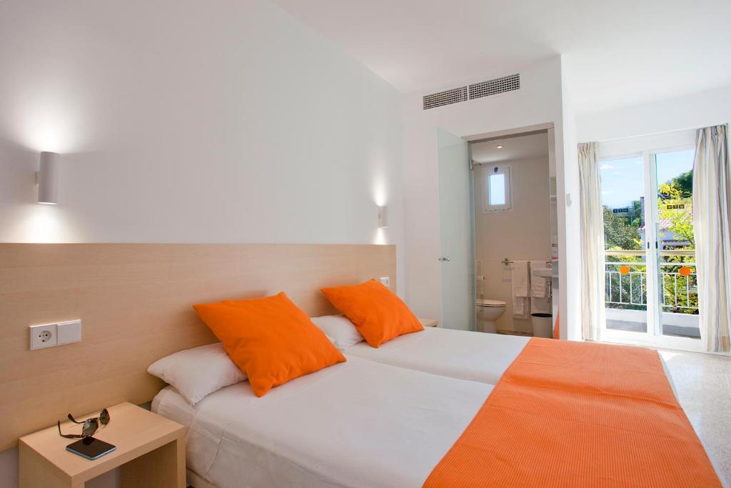 a bedroom with a large bed with orange pillows at Mix Peru Playa in Playa de Palma