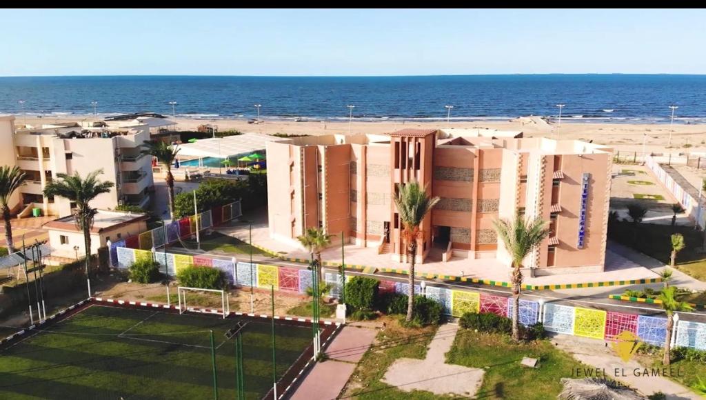 uma vista para uma praia com edifícios e o oceano em Jewel El Gameel Hotel em Port Said