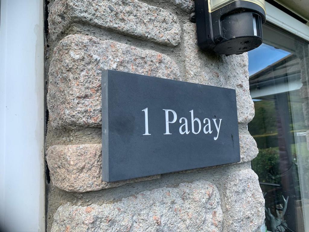 a sign that says ionday on a stone wall at Pabay@Knock View Apartments, Sleat, Isle of Skye in Teangue