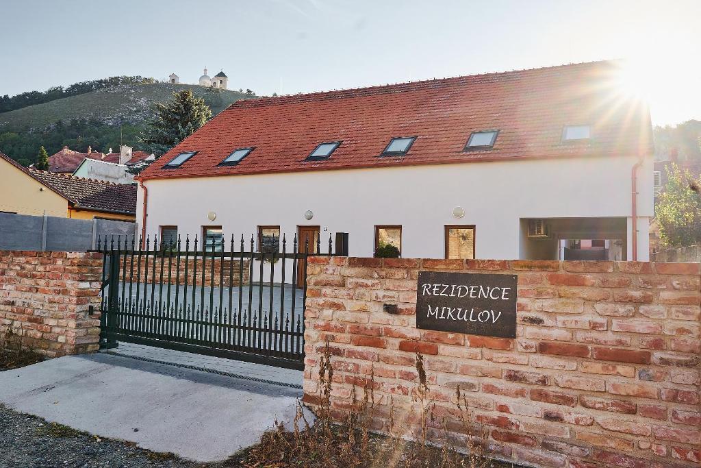 a building with a sign in front of a brick fence at Apartmán NEWSTALGIE in Mikulov