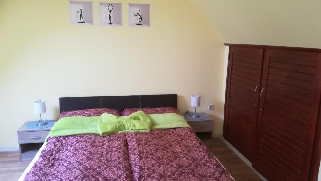 een slaapkamer met een bed met een gele boog erop bij MA-JA 4 in Bük