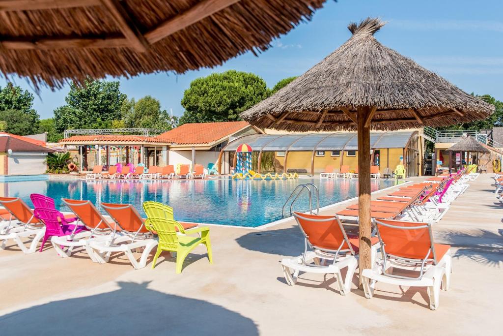 a group of chairs and a swimming pool at Camping Club Le Littoral - Maeva in Argelès-sur-Mer